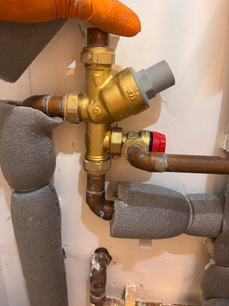 Brass combination valve group on the cold supply to an unvented cylinder with a red-capped relief valve