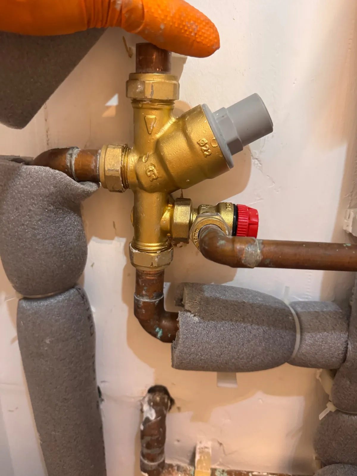 Brass combination valve group on the cold supply to an unvented cylinder with a red-capped relief valve